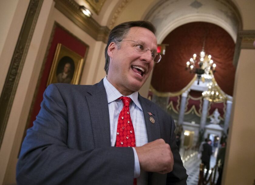 Rep. Dave Brat, R-Va., a member of the conservative House Freedom Caucus, speaks with a reporter just before passage of the Republican tax reform bill in the House of Representatives on Tuesday. J. Scott Applewhite/Associated Press