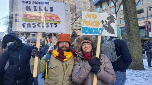 Chris Petruccelli, left, and Laurel McKenzie hold signs at a protest on Martin Luther King Jr. Day in Chicago on Jan. 19. What’s happening now in the U.S. “is too important to not show up,” he said.