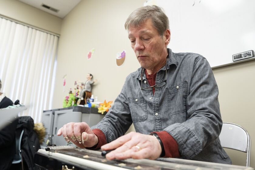 Carl Hix, the instructor of The Hix Bros Ukulele Band, plays an eight-string double-neck Hawaiian steel guitar at Musical Expressions in Naperville, Saturday, Jan. 27, 2024.