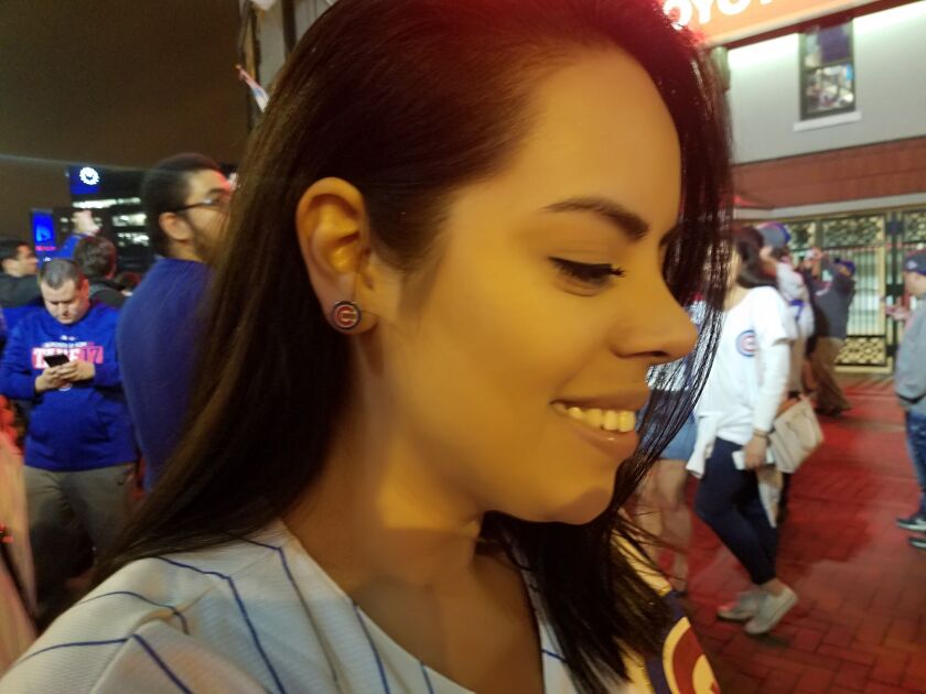 Cub fan Jessica Castrejon shows off her “lucky earring” that she says helped the team lock up an NLDS win on Thursday. | Nader Issa/Sun-Times
