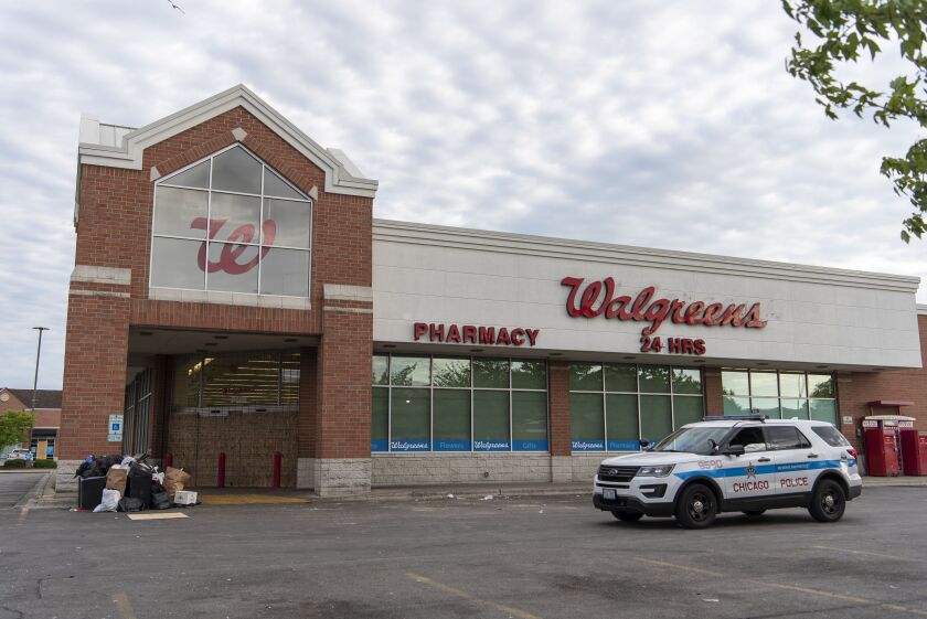 A Chicago police vehicle sits in front of a boarded up Walgreens at 8628 South Cottage Grove Ave. on Monday, June 1, 2020, after a string of looting that occurred throughout the city.