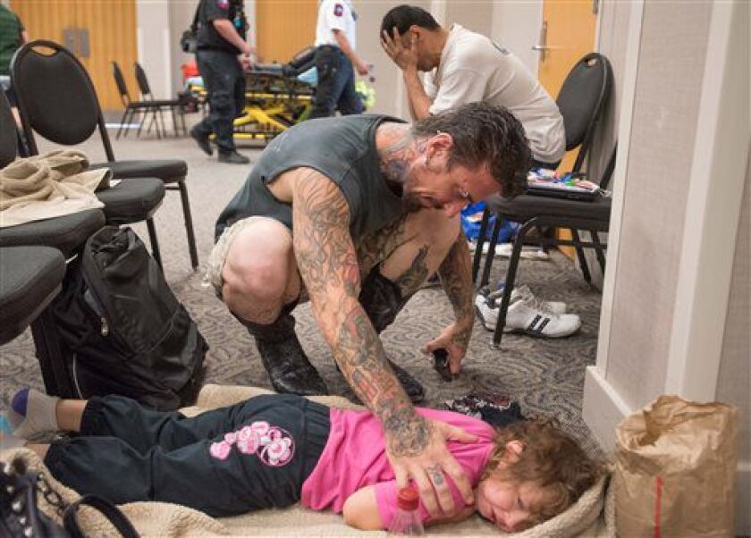 <small><strong>David Barry consoles his 5-year-old daughter, Marley, while she tries to sleep in a flood evacuee room created at the San Marcos Activity Center on Sunday in San Marcos, Texas. The Barry family was evacuated from their apartment at 4 a.m. S
