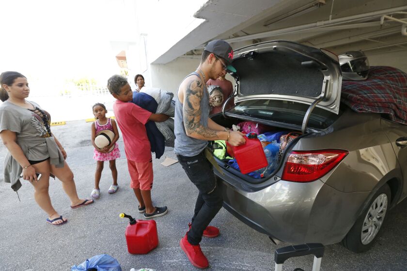 Luis Garcia, right, packs a car that he and five other members of his extended family will use to evacuate north from their home in Miami Beach, Fla. | Wilfredo Lee/Associated Press