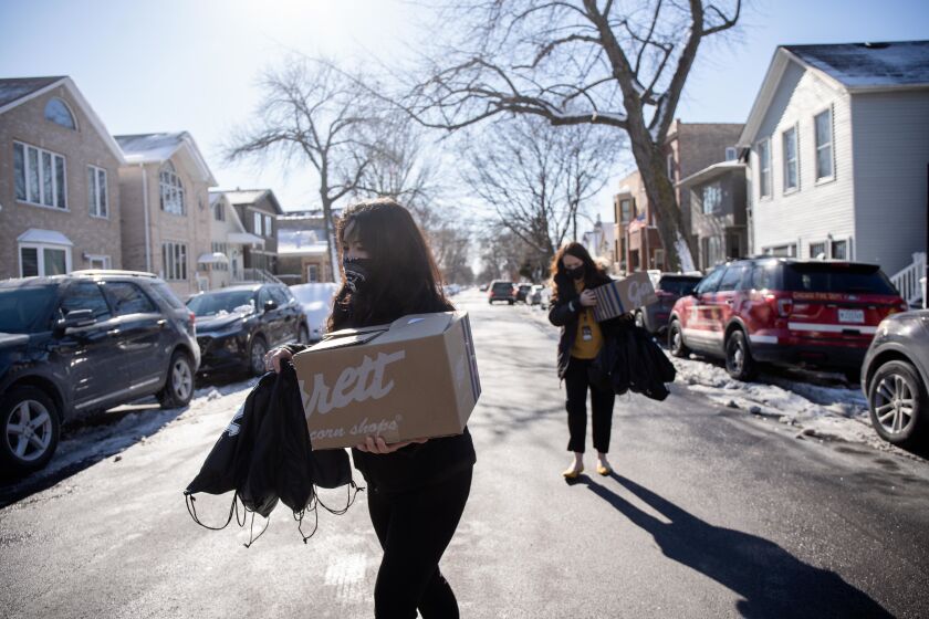 White Sox staffers carry donated food to Chicago Fire Department firefighters Thursday at Engine 29 in Bridgeport. White Sox pitcher Liam Hendriks and his wife Kristi donated lunch from local restaurants to about half a dozen firefighters.