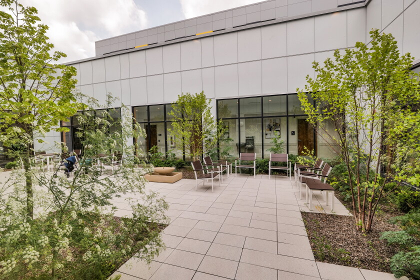 The building's glass-walled first floor hallway provides views and access to a landscaped courtyard.