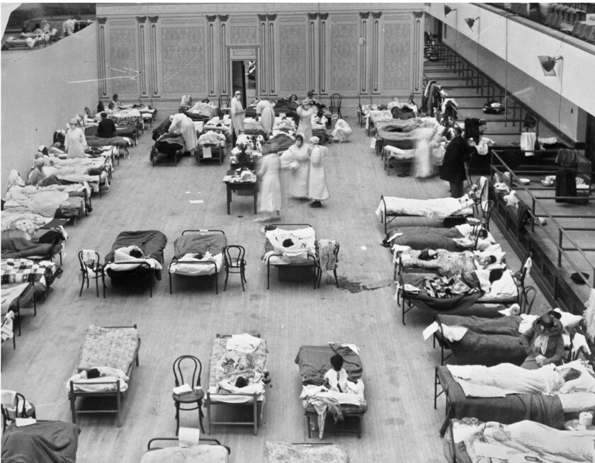 In this photo from the Library of Congress, American Red Cross volunteer nurses tend to patients at the Oakland City Auditorium during the 1918 flu pandemic.