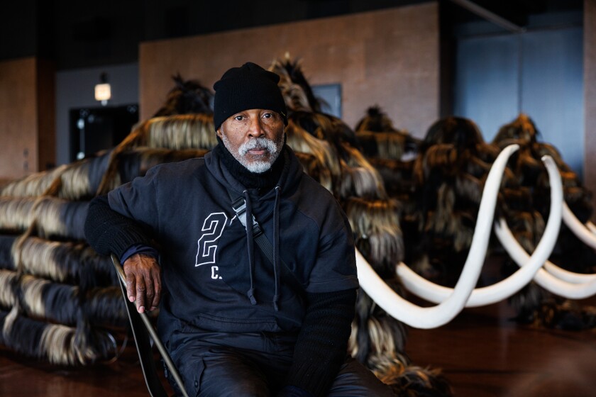 Artist Nick Cave sits in front a wooly mammoth that will be controlled by four dancers for his work “Nick Cave: Mammoth” during a video shoot at the Theater by the Lake at North DuSable Lakeshore Drive and West Fullerton Parkway on the lakefront, Tuesday, Jan. 13, 2026.