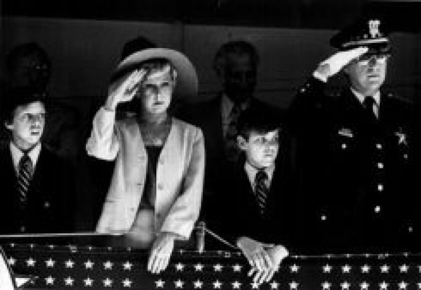 Mayor Byrne and Police Supt. Richard J. Brzeczek, with his two sons, salute police units passing the reviewing stand during a St. Jude Police League parade through the Loop. | File photo
