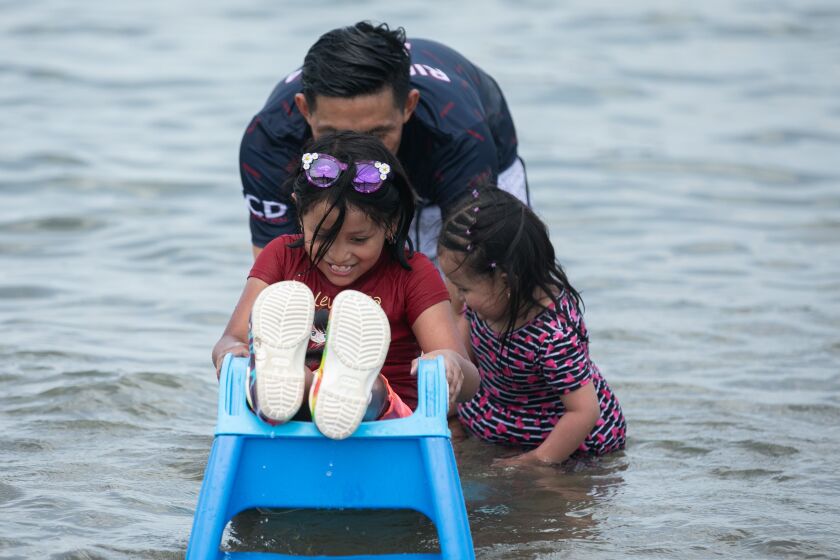A family takes a dip in Lake Michigan at Montrose Beach as temperatures rise to 95 degrees, Wednesday afternoon.