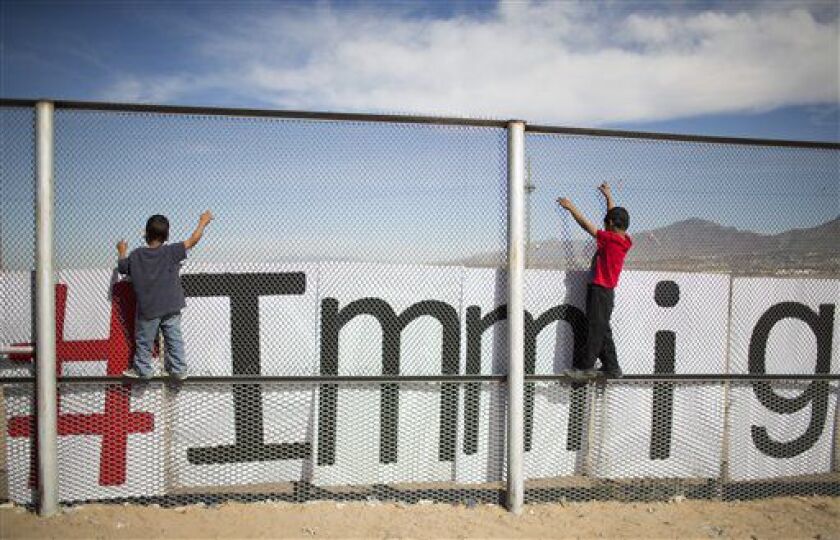 Two small boys balance themselves on the rail of a border fence during an event organized by the Border Network for Human Rights, on the outskirts of Ciudad Juarez, Mexico, Monday, Feb. 15, 2016. Pope Francis will conclude his weeklong Mexico trip with a