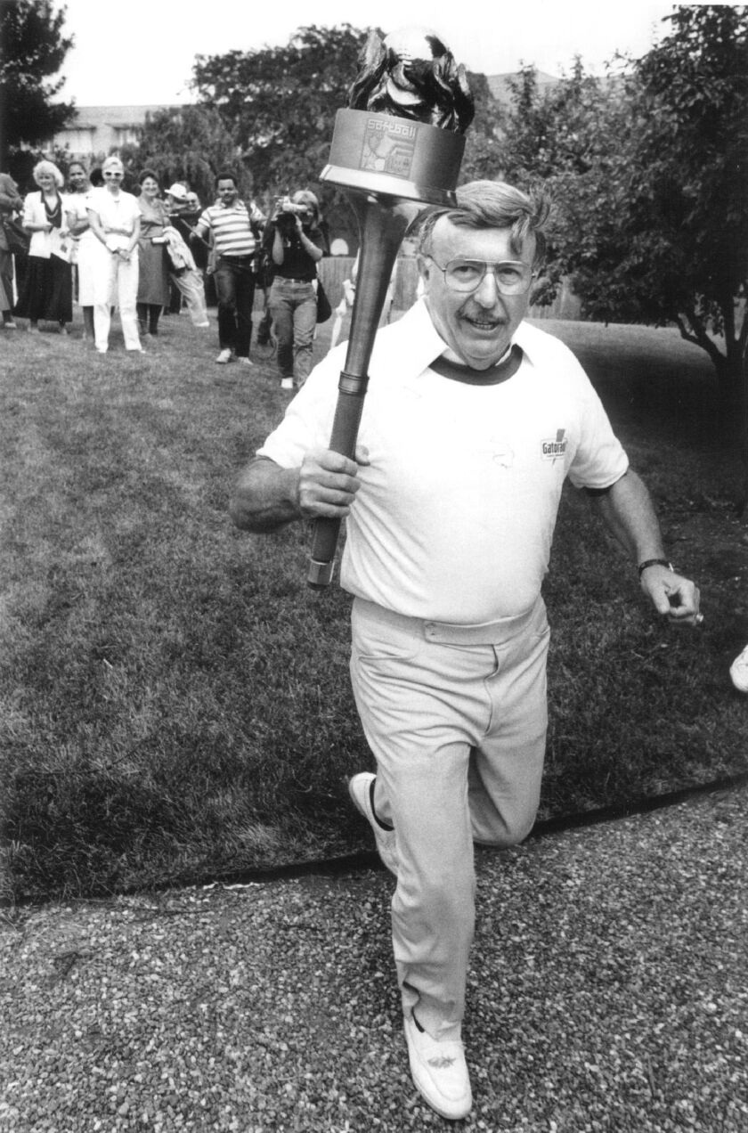 Ed Zolna carries the torch at a the start of a relay from Chicago to the Softball Hall of Fame in Oklahoma in a ceremony celebrating softball’s 100th anniversary. | Rich Hein/Sun-Times