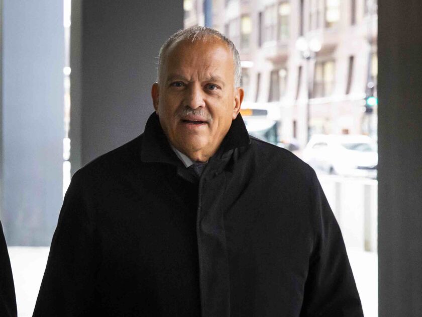 Ex-State Rep. Luis Arroyo walks into the Dirksen Federal Court Building Tuesday before he pleads not guilty to a bribery charge.