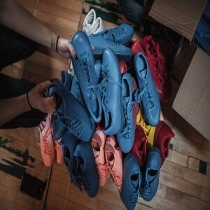 A large pile of shoes gets sorted before being packed up for distribution day at Kicks 4 The City.