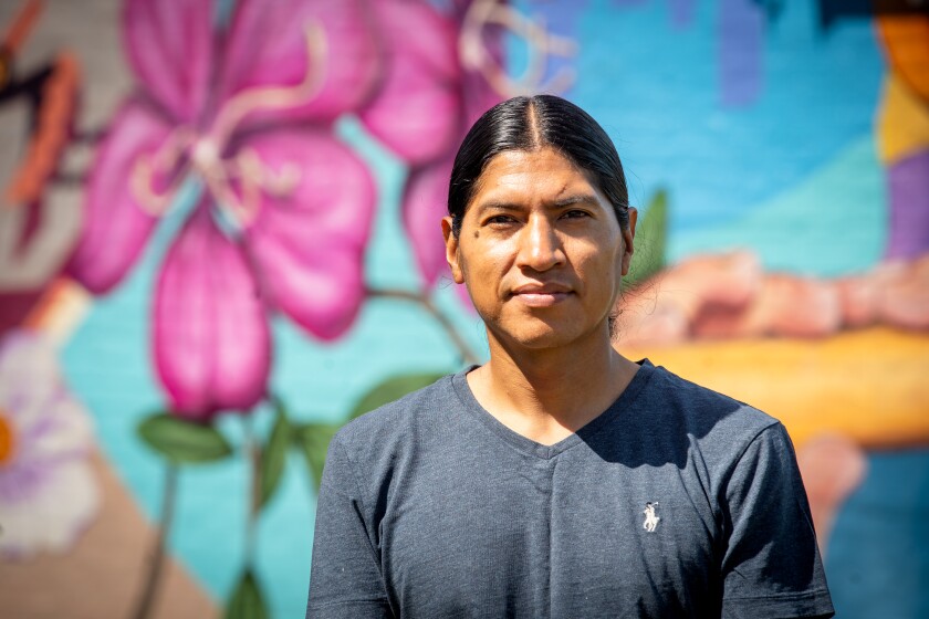 Fernando Lechón stands in front of his mural that honors indigenous Ecuadorian culture.