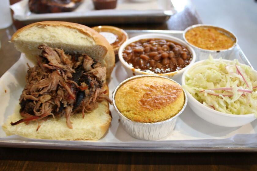 Pulled pork sandwich with sides of beans, mac and cheese, cornbread and coleslaw from Smoque BBQ. | Brian Rich/For the Sun-Times