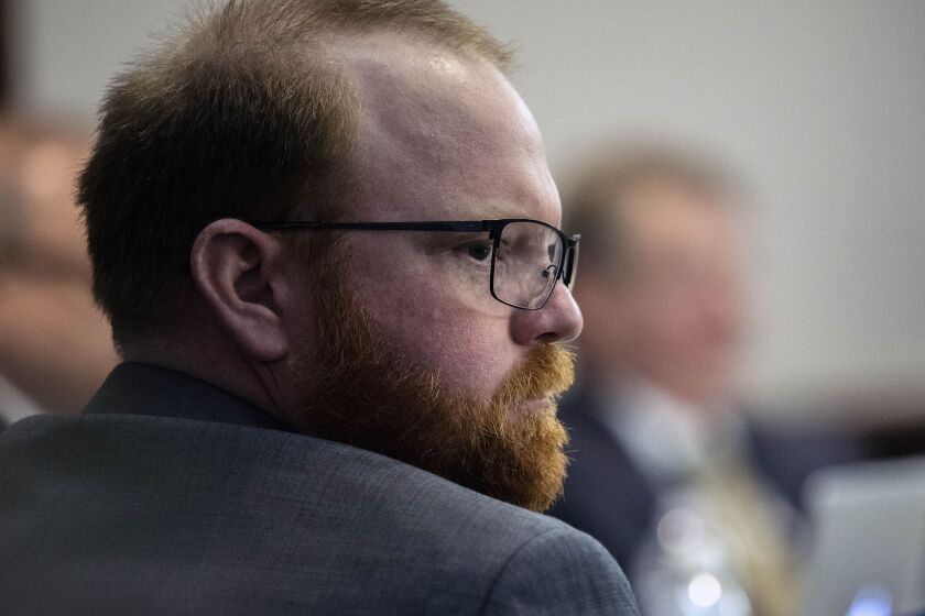 Travis McMichael sits with his attorneys before the start of closing arguments to the jury during the trial of he, and his father Greg McMichael, and William “Roddie” Bryan, at the Glynn County Courthouse, Monday, Nov. 22, 2021, in Brunswick, Ga.