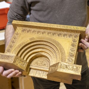 Bill Bauman, senior designer at Columbian Model & Exhibit Works, holds one of the workshop's oldest models, which depicts Louis Sullivan's "Golden Doorway."