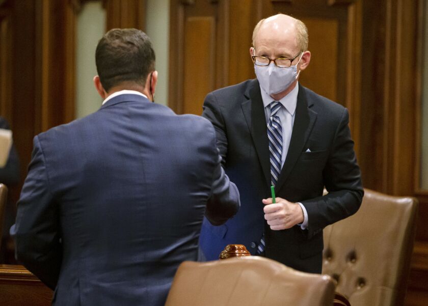 State Senate President Don Harmon, D-Oak Park, shakes hands with state Sen. Michael Hastings, D-Tinley Park, on the floor of the Senate early Wednesday.