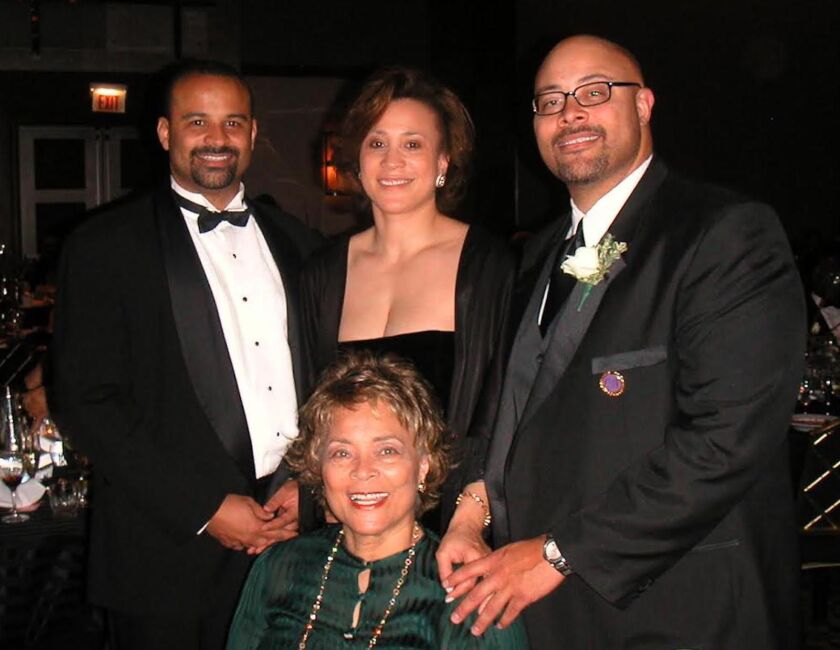 Juanita M. Gibson (seated) with daughter Dr. Kim Meyer and sons John (left) and Hank (right).