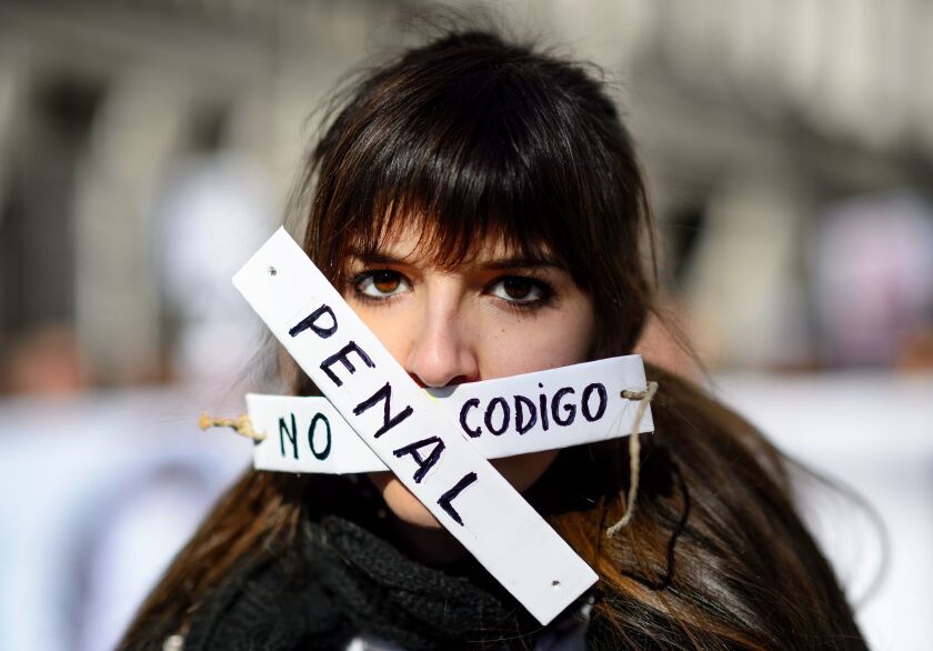 A woman covers her mouth with strips that read “no penal code” as she takes part in a demonstration called by the “Dignity Marches” platform against the new public security law, dubbed “ley mordaza” (gag law), in Madrid on January 25, 2015. DANI POZO/AFP/