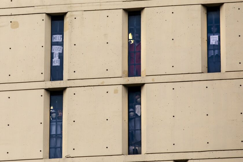 Inmates at the Metropolitan Correctional Center hold up signs reading, “please help” and “virus is here” during the coronavirus pandemic, Monday afternoon, April 20, 2020.