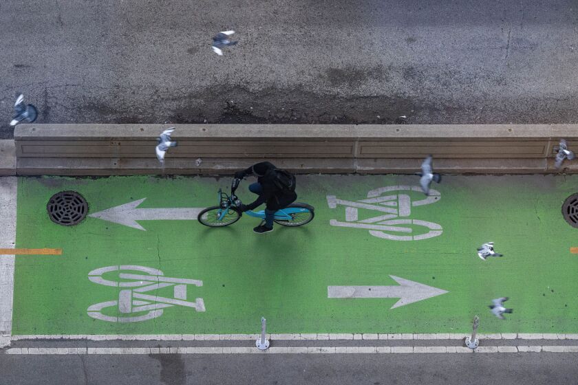A cyclist rides along a greenway on North Dearborn Street near Daley Plaza in the Loop.