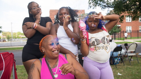 Kendall Averhart reacts as daughter Kendria Averhart (9) blows bubbles at Kendra Averhart (12) and Keivona Averhart (15) during the 97th Bud Billiken Parade in Bronzeville on Saturday, Aug. 8, 2026.
