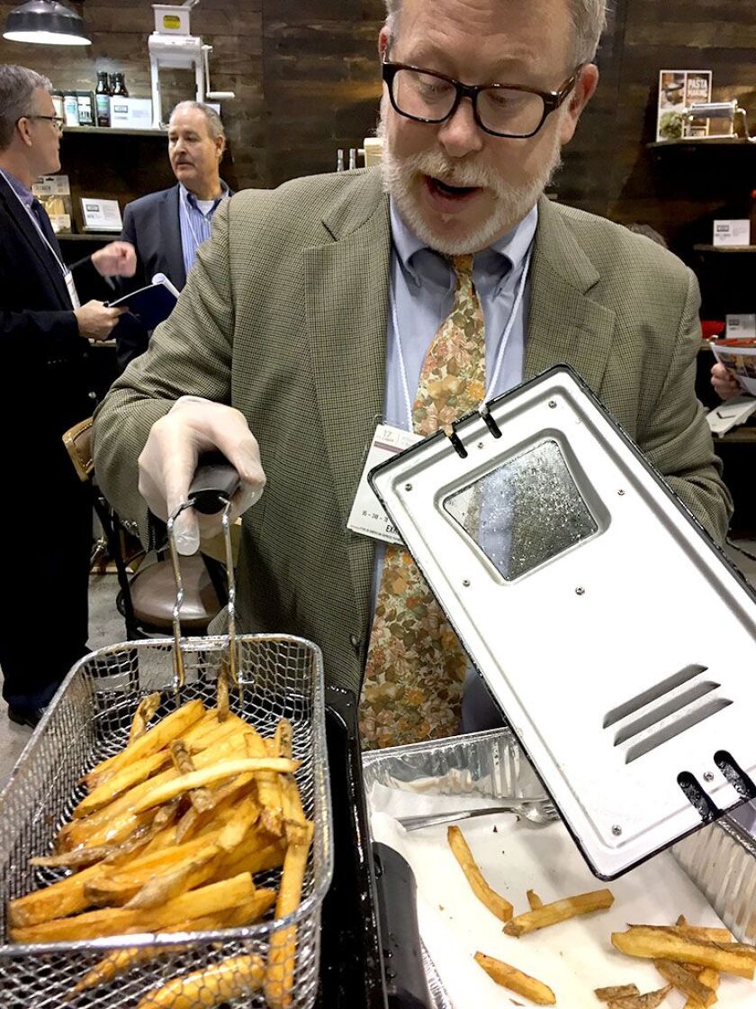 John Haddad, assistant brand manager at Hamilton Beach Brands, makes french fries in an eight-cup deep fryer with Realtree camouflage top at the 2017 International Home + Housewares Show. | Neil Steinberg/Sun-Times