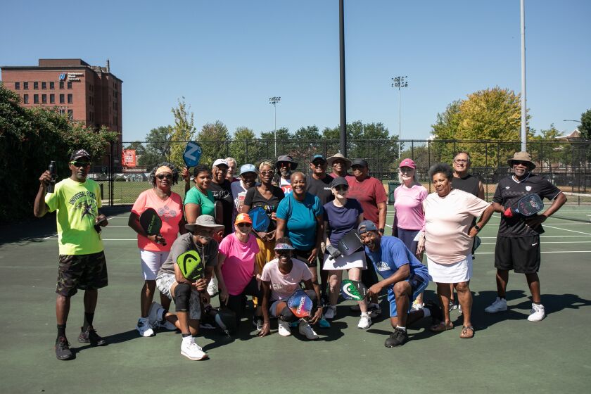 Pickleball players stand together at Mandrake Park on the South Side, Wednesday, Aug. 31, 2022. The group, composed mostly of older adults, typically meet thrice a week to play the sport, which they say keeps them healthy and creates a community.
