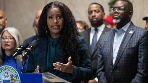 Chicago Teachers Union President Stacy Davis Gates speaks in front of Chicago Mayor Brandon Johnson during a news conference at City Hall in the Loop, where he announced that he signed two executive orders and that he decided against vetoing the alternate budget that City Council passed, Tuesday, Dec. 23, 2025.