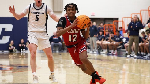 Curie's Justin Oliver (12) drives toward the basket against New Trier last season.