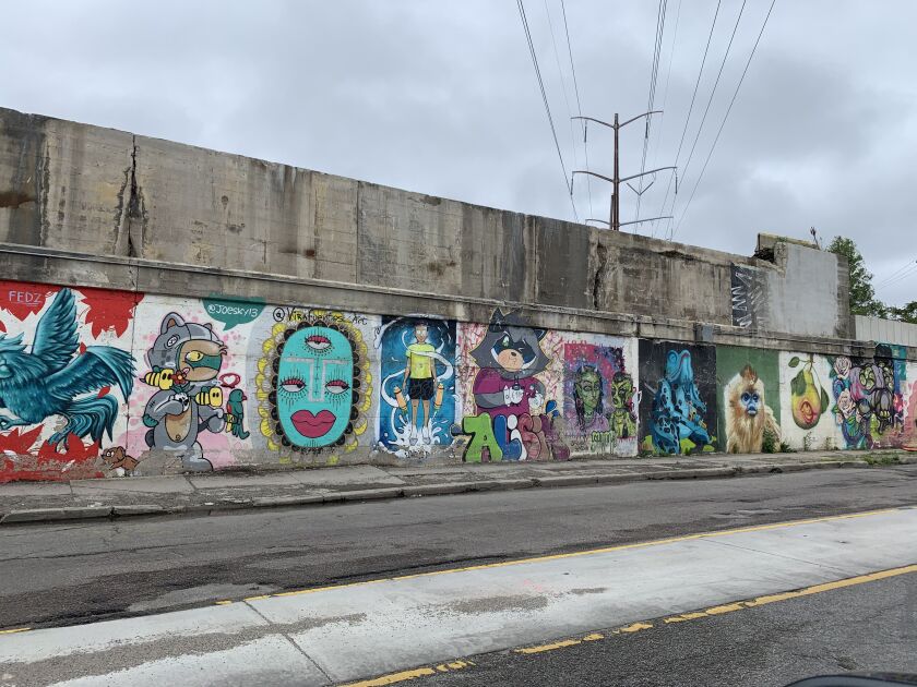 A stretch of murals created at the 2019 “Meeting of Styles” event. The painting of the three-eyed, red-lipped, aqua-colored face, set against a silver background, was done by 32-year-old artist Natalia Virafuentes, who lives in Albany Park. She says it’s “a reflection of yourself and looking within, trying to bring good out in the world. I love the city, I wish I could cover it all.’