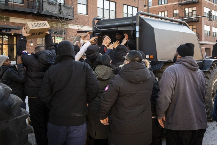 Kanye West’s team hands out free pairs of his much-anticipated Yeezy QNTM (Quantum) shoes on West Madison near South Leavitt, just west of the United Center, Friday afternoon, Feb. 14, 2020.