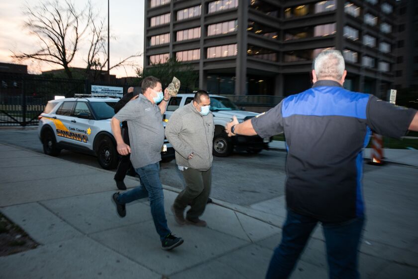 Police officer Ruben Reynoso, in grey jacket, and Sgt. Christopher Liakopoulos, in black hoodie, run to a car after posting bond and walking out of Cook County Jail Friday, Sept. 16, 2022. Liakopoulos and Reynoso are charged with aggravated battery with a firearm, aggravated discharge of a firearm and official misconduct for allegedly opening fire on Miguel Medina, a 23-year-old man who Cook County State’s Attorney Kim Foxx said was not armed with a gun, in Pilsen in July.