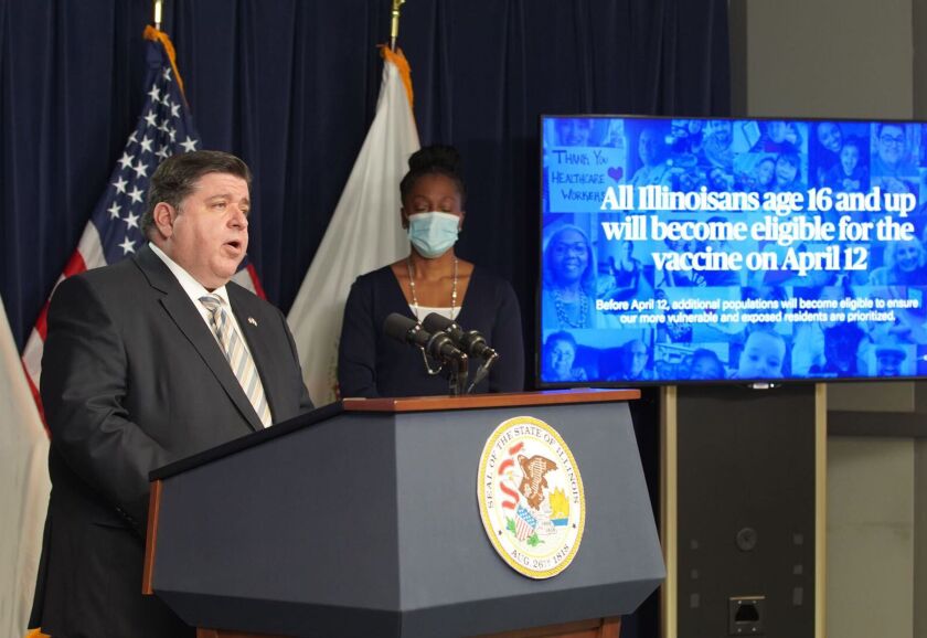 Gov. J.B. Pritzker speaks at a March news conference. To his left is Ngozi Ezike, head of the Illinois Department of Public Health.