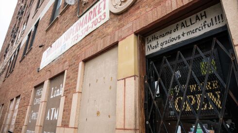 A sign that reads, “In the name of Allah, most gracious + merciful!!!” is posted on the door of El Barakah Supermarket in the South Shore neighborhood, Saturday, Nov. 12, 2022, where Ali Hassan was fatally shot a night earlier.