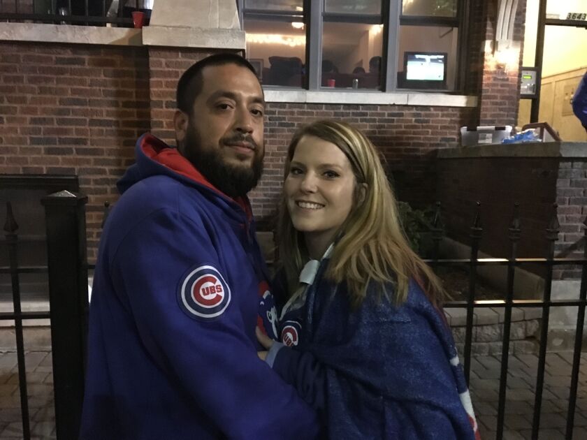 Jaime Ponce (right) and his finacé, Letticia Kinch, watch the Cubs game on TV through an apartment window. | Jacob Wittich/Sun-Times