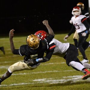 Yorkville’s Ben Stemmet (18) lays a hard hit on Richards senior Marquel Porter (5). Worsom Robinson/For the Sun-Times.