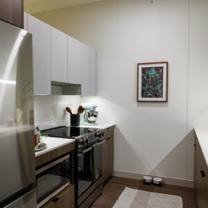 The kitchen with an electric stove and stainless steel fridge, inside a model one-bedroom unit at 65 E. Wacker Place.