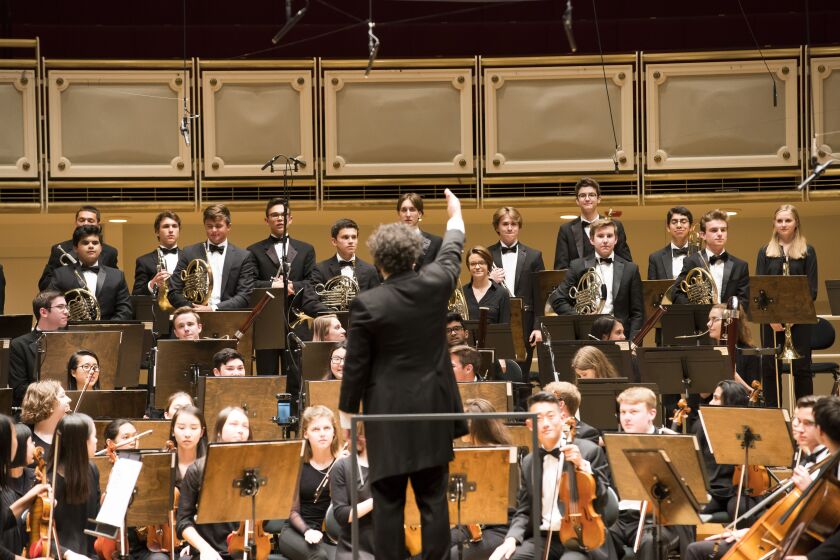 Chicago Youth Symphony Orchestra (CYSO) conductor Allen Tinkham acknowledges student musicians following the world premiere of Michael Abel’s Winged Creatures. The performance was part of the League of American Orchestras conference events in Chicago. | ©