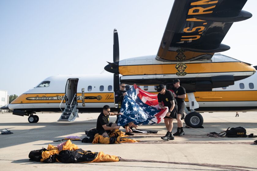 The U.S. Army Golden Knights parachute team prepares a large American flag at the Gary/Chicago International Airport in Gary before their practice jump Friday for the weekend’s 2023 Chicago Air and Water Show.