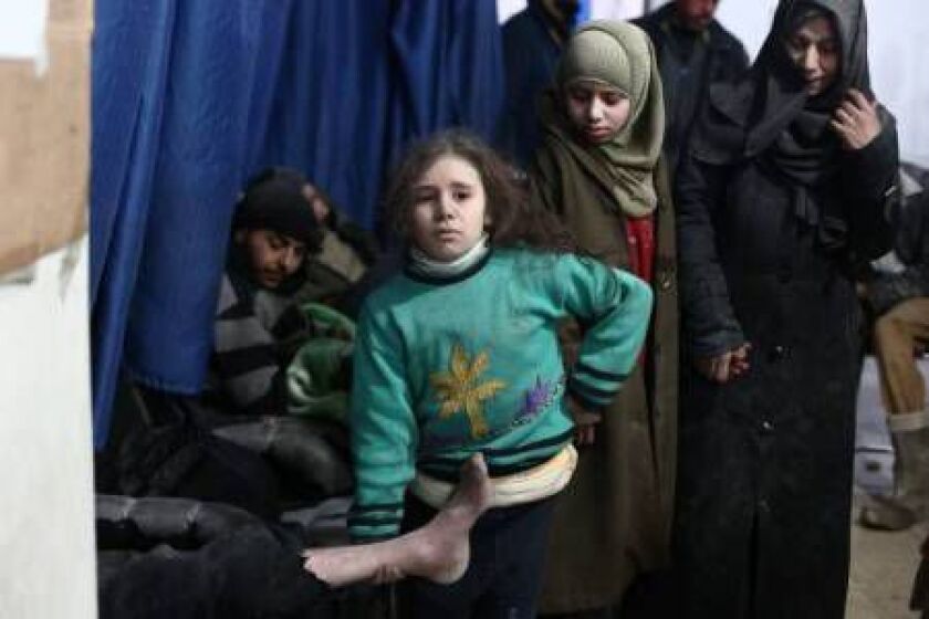 A Syrian girl holds the leg of her injured father as they wait for treatment at a clinic in the rebel-held area of Douma, east of the capital Damascus, following reported air strikes by regime forces on February 9, 2015. ABD DOUMANY/AFP/Getty Images