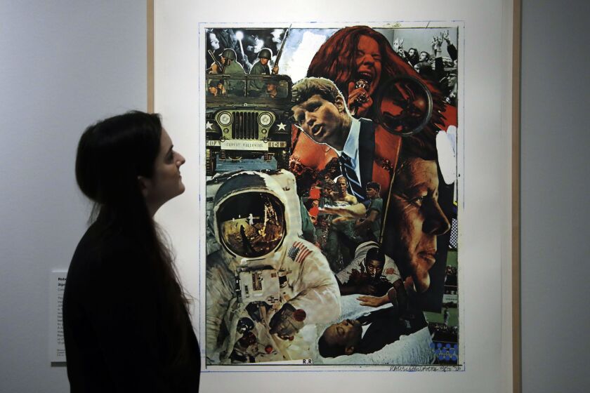 A British Museum representative poses for photographs next to Robert Rauschenberg’s “Signs”, 1970, which features in “The American Dream: Pop to the Present” exhibition at the British Museum in London, Monday, March 6, 2017. (AP Photo/Matt Dunham)