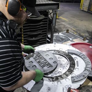 Moldline supervisor Aaron Christianson assembles the pattern for a new city of Chicago manhole cover at Neenah Foundry in Neenah, Wisconsin, which has made the city’s infrastructure for almost 100 years, Friday, April 8, 2022.