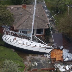 A sailboat is shoved up against a house and a collapsed garage Saturday, Sept. 15, 2018, after heavy wind and rain from Florence, now a tropical storm, blew through New Bern, N.C. (AP Photo/Steve Helber)