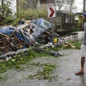 A man looks at a damaged house due to strong winds from Typhoon Mangkhut as it barreled across Tuguegarao city in Cagayan province, northeastern Philippines on Saturday, Sept. 15, 2018. The typhoon slammed into the Philippines northeastern coast early Sat