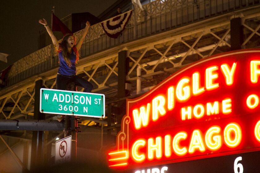 Fans climb on street poles outside Wrigley Field as the Chicago Cubs take on the Cleveland Indians at Progressive Field for Game 7 of the World Series, Wednesday night, Nov. 2, 2016. | Ashlee Rezin/Sun-Times