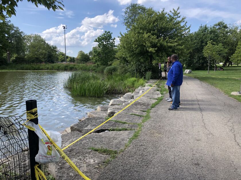 Humboldt Park lagoon surrounded by crime scene tape during alligator search.