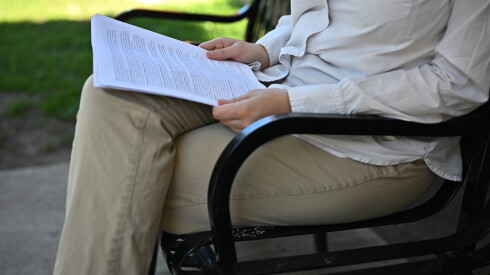 A woman looks at health insurance paperwork in a Chicago park.