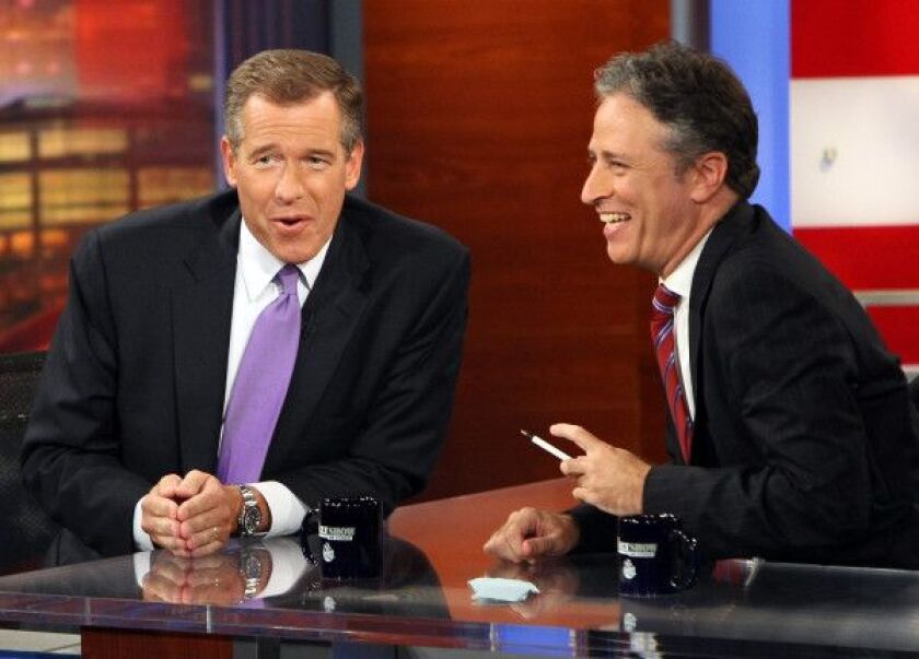 NBC News anchor Brian Williams (L) is interviewed by host Jon Stewart of Comedy Central’s “The Daily Show with Jon Stewart” during a taping of “The Daily Show with Jon Stewart: Restoring Honor & Dignity to the White House” at the McNally Smith College